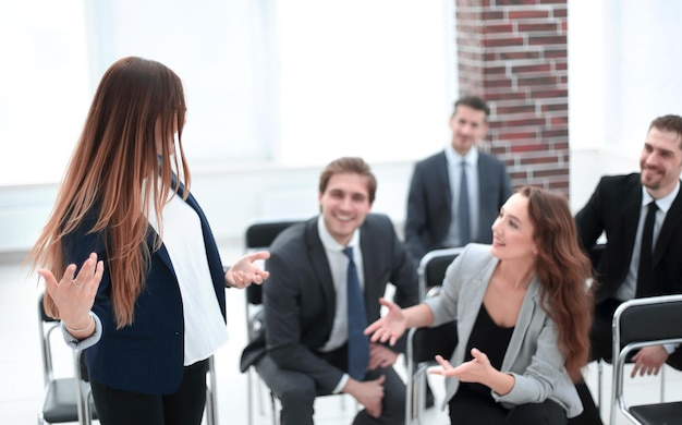 Bizneswomany i biznesmeni śmieją się rozmawiając na spotkaniu grupowym koledzy bawią się omawiając pracę na odprawie zespołowej siedząc razem na konferencji