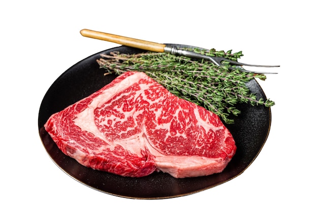 Black Angus Rib Eye steak surowe mięso wołowe z ziołami izolowane na białym tle