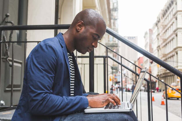 Black Guy Using Notebook In New York