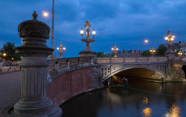 Zdjęcie blauwbrug blue bridge nad rzeką amstel w amsterdamie w wiosenny wieczór holland