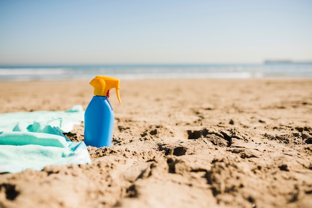 Błękitna Butelka Słońce Ekranu Balsam Na Piaskowatej Plaży