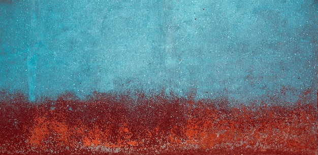 Błękitna i czerwona grunge betonowa ściana z foremką na nim.