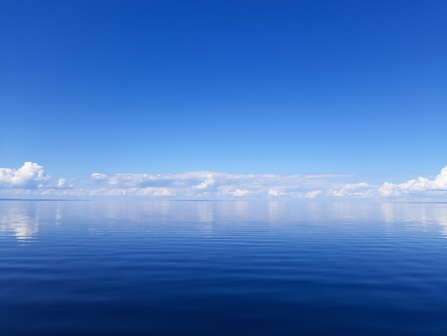 Błękitna woda łączy się z błękitnym morzem Niebieskie zdjęcie w tle Spokój nad jeziorem i słoneczna pogoda
