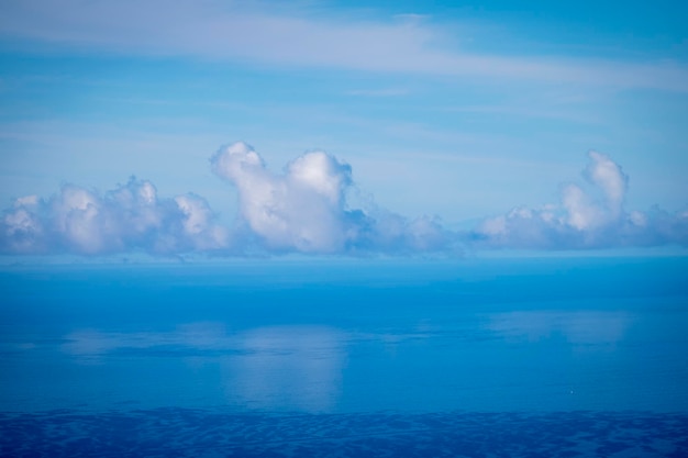 Błękitna woda morze ocean widok tło z białymi obłokami. Piękne niebo odbijające się w tafli wody. Koncepcja niesamowitego miejsca docelowego i spokojnej przyrody na świeżym powietrzu