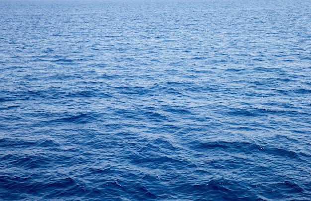Błękitna woda z odbiciami słońca Morze w tle