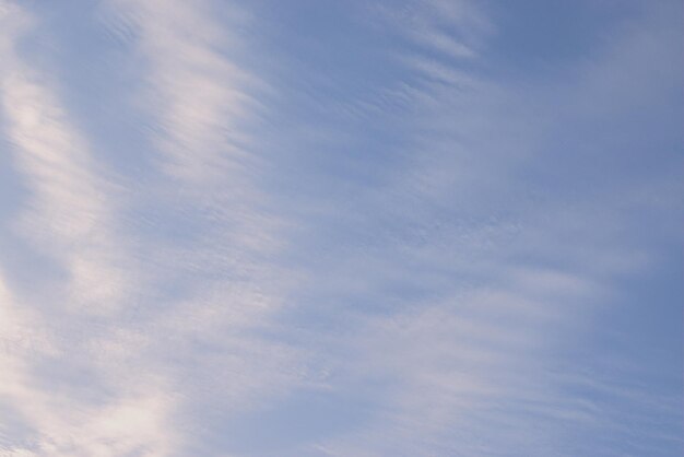Błękitne niebo, na którym białe chmury i wiatr malowały obraz w stylu abstrakcji