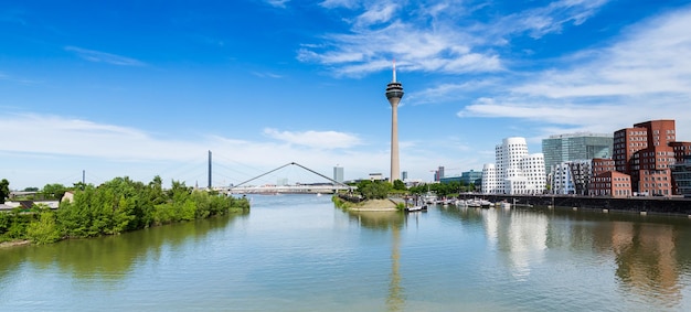 Błękitne niebo z chmurami latem w Düsseldorfie Wieża Rheinturm i most NordrheinWestfalen Niemcy Europa