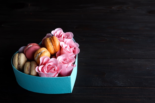 Błękitnego Serca Pudełko Z Macaroons I Wzrastał Na Ciemnym Drewnianym Tle