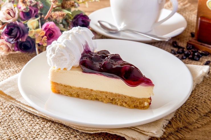 Zdjęcie błękitny jagodowy cheesecake i kawa na drewnianym stole