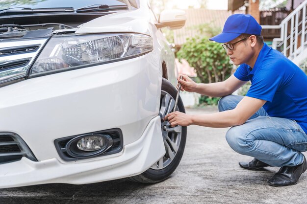 Bliska auto mechanik człowiek sprawdza oponę samochodową Serwis samochodowy Ręce wymieniają opony na kołach Koncepcja instalacji opon