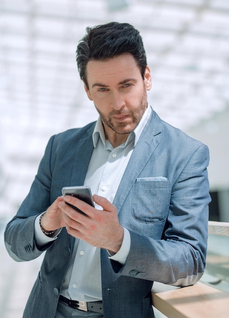 Bliska biznesmen patrząc na ekran smartfona koncepcja telefonii