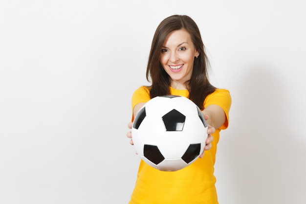 Bliska całkiem Europejskiej młoda uśmiechnięta szczęśliwa kobieta, fan piłki nożnej lub gracz w żółtym mundurze trzymając piłkę nożną na białym tle. Sport, grać w piłkę nożną, zdrowie, koncepcja zdrowego stylu życia.