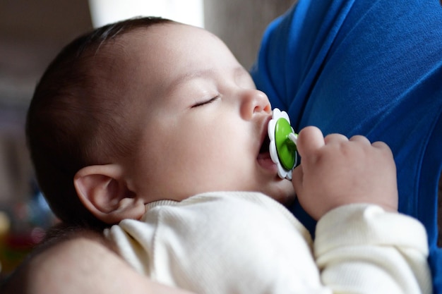 Bliska, Cute noworodków śpiących w ramionach ojca Kochający ojciec nosi w domu swoje nowo narodzone dziecko Portret szczęśliwej matki trzymającej śpiące dziecko