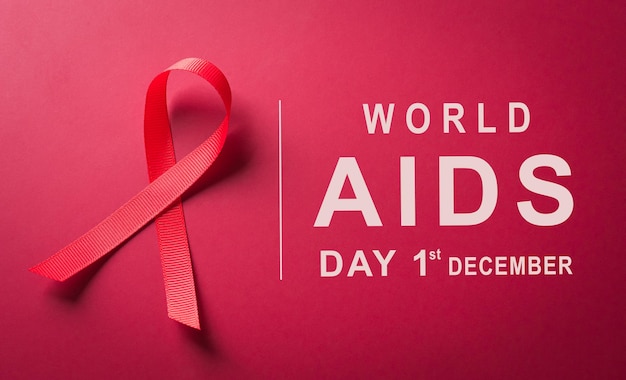 Bliska czerwona wstążka Światowy Dzień Świadomości HIV AIDS wstążka na czerwonym tle Koncepcja opieki zdrowotnej i medycyny