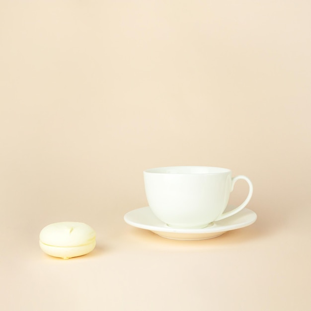 Bliska Francuski Delikatny Deser Na śniadanie Z Porcelanowym Białym Kubkiem Na Filiżankę Kawy Na Beżowym Pastelowym Tle Wykwintne Kolorowe Ciasteczka