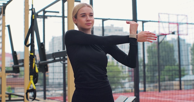 Bliska kobieta rozciąganie ramienia ramię mięśni elastyczne ćwiczenia fitness trening na boisku sportowym Trening fizyczny Zdrowy styl życia