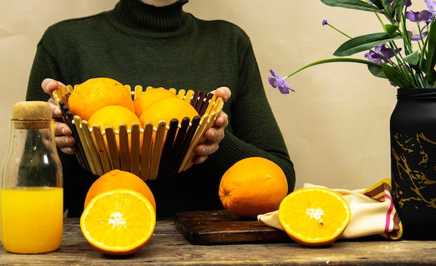 bliska kobieta trzymająca koszyk świeżego soku pomarańczowego z owocami