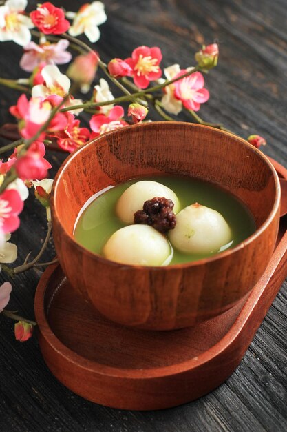 Bliska Matcha Big Tangyuan (tang Yuan) Ze Słodką Zupą Matcha W Drewnianej Misce Na Tle Czarnego Drewnianego Stołu Na Festiwal żywności Przesilenie Zimowe