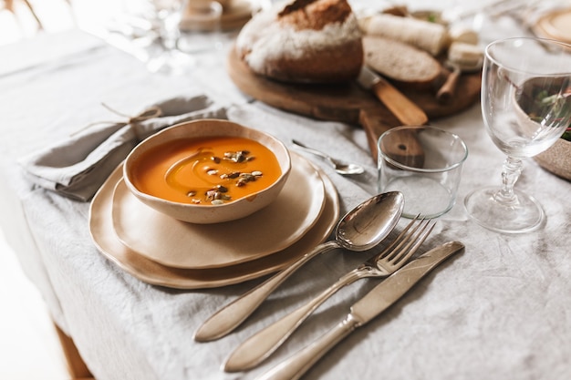 Bliska Miskę Kremowej Zupy Dyniowej I świeżego Chleba Na Pokładzie Drewna Na Lunch W Przytulnej Kawiarni