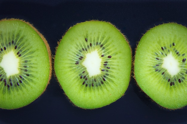 bliska Plasterki organicznych Kiwi na czarnym tle