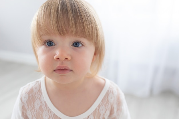 Bliska portret kaukaska dziewczynka dziecko w białym pokoju