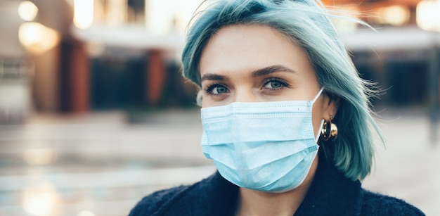 Bliska portret niebieskich włosach rasy kaukaskiej kobiety noszącej specjalną maskę przeciw grypie podczas