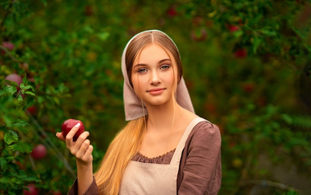 Bliska portret pięknej dziewczyny w średniowiecznej sukni z jabłkiem. Bajka.