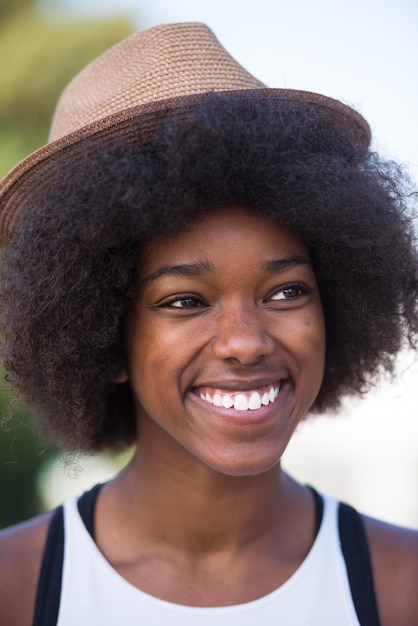 Bliska portret pięknej młodej Afroamerykanki uśmiechającej się i patrzącej w piękny słoneczny dzień