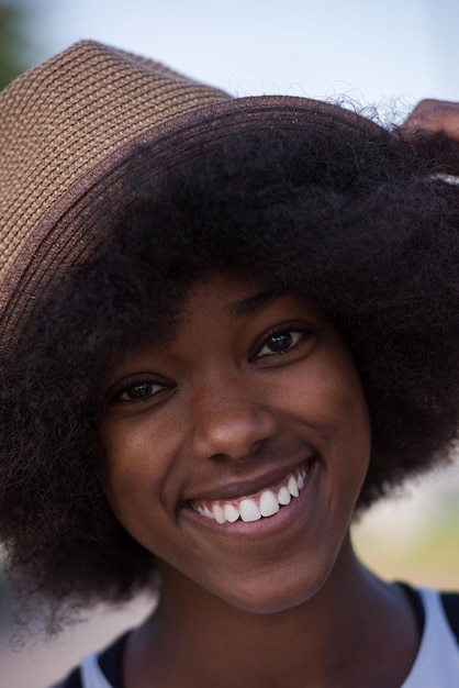 Bliska portret pięknej młodej Afroamerykanki uśmiechającej się i patrzącej w piękny słoneczny dzień