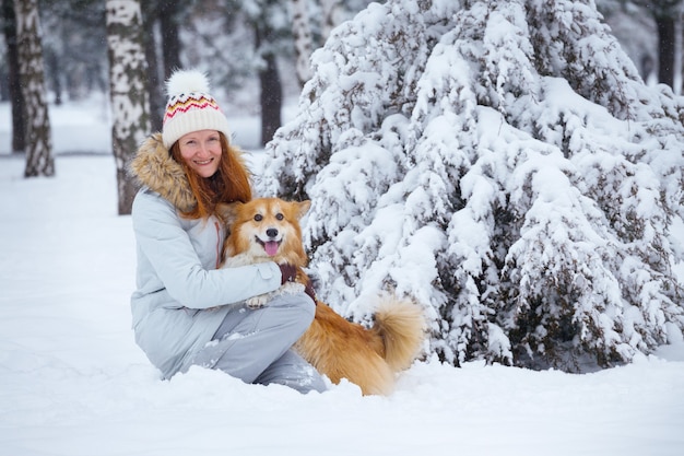 Bliska portret psa corgi puszysty i jego właściciel bawiący się na zimowy spacer na świeżym powietrzu