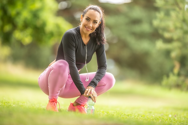 Bliska portret uśmiechający się sportowy atrakcyjna młoda kobieta na zewnątrz.