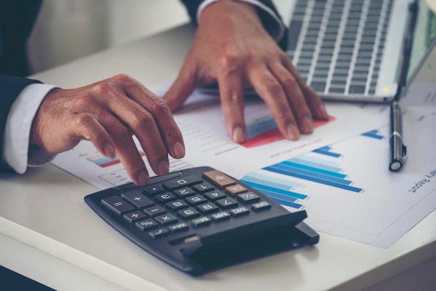 Bliska ręce człowieka biznesu za pomocą kalkulatora licząc podatek finansowy rachunek Ręce człowieka obliczania liczby danych wykres wykres audytu planowanie księgowość na raport biznesowy Kontrola podatkowa Finansowa koncepcja