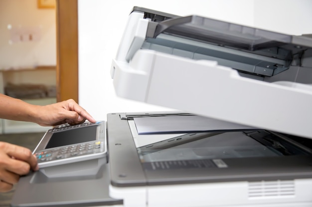 Bliska ręka biuro człowiek naciśnij przycisk na kopiarce.