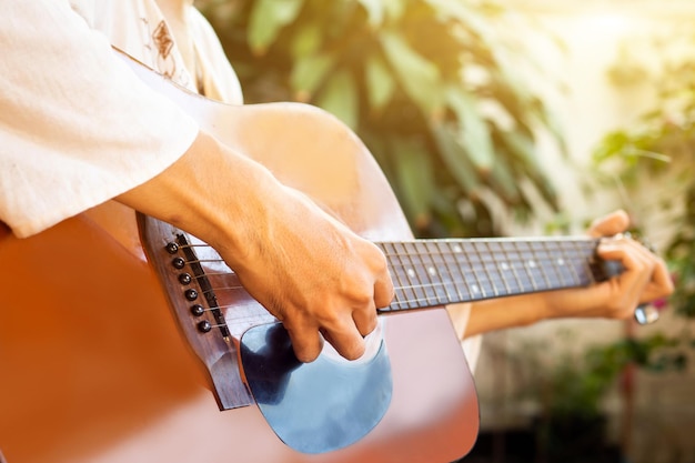 Bliska ręka ludzi grających na gitarze na gitarze akustycznej Selektywne skupienie