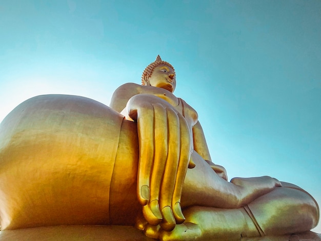 Bliska Ręka Wielkiego Posągu Buddy Z Błękitne Niebo W Tajlandii Wat Tha Muang. Najbardziej Charakterystyczne Posągi Złotego Buddy