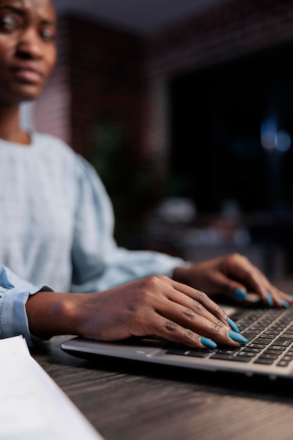 Bliska strzał african american giełdowego handlowca forex przy biurku, za pomocą laptopa do analizowania wykresów finansowych na żywo. Pracownik firmy maklerskiej pracujący na komputerze podczas przeglądania danych handlowych.