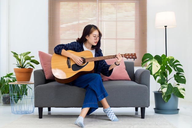 Bliska Szczęśliwe Okulary Azjatycka Dziewczyna Gra Na Gitarze Akustycznej W Salonie W Domu Koncepcja Rekreacji W Domu