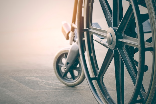 bliska widok wózka inwalidzkiego z symbolem niepełnosprawności chodnika