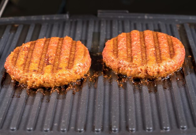 Zdjęcie bliskie ujęcie mięsa, takich jak paszteciki na bazie roślin do wegetariańskich burgerów wołowych grillowanych na gorącej patelni