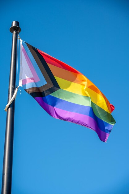 Bliskie zdjęcie flagi Rainbow LGBT latającej na niebieskim tle