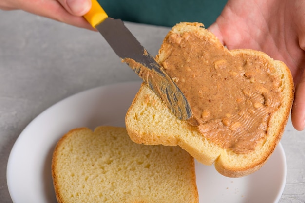 Blisko do białego toastu z masłem orzechowym i nożem amerykańskie śniadanie