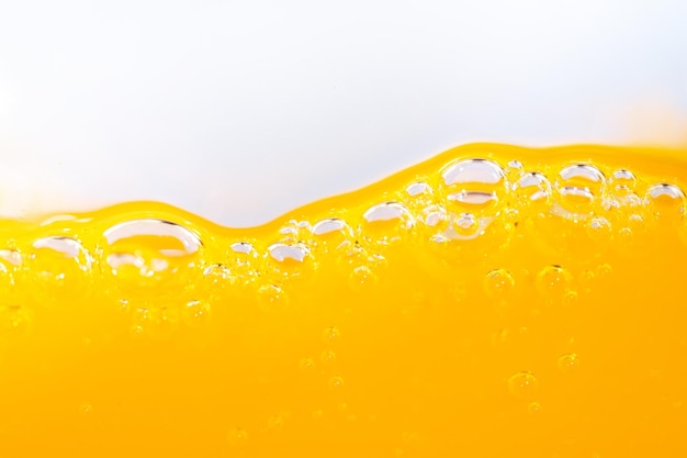 Zdjęcie blisko jasny sok pomarańczowy strumień tekstury dla zdrowia i natury fale piękne fale krzywe i małe pęcherzyki gładkie dla garficznego projektu i tła