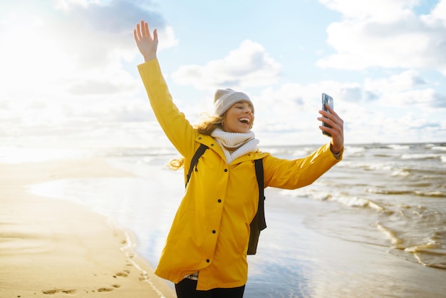 Blogerka podróżnicza robi selfie dla sieci społecznościowych przy zachodzie słońca w morzu Koncepcja turystyki podróżnej i relaksu