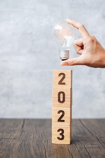 Blok 2023 z żarówką Pomysł na biznes Kreatywne myślenie Burza mózgów Plan strategii rozwiązania celu Zmiana działania i koncepcje rozpoczęcia Nowego Roku