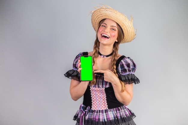 Blond brazylijska kobieta w czerwcu ubrania imprezowe arraial smartfon zielony ekran