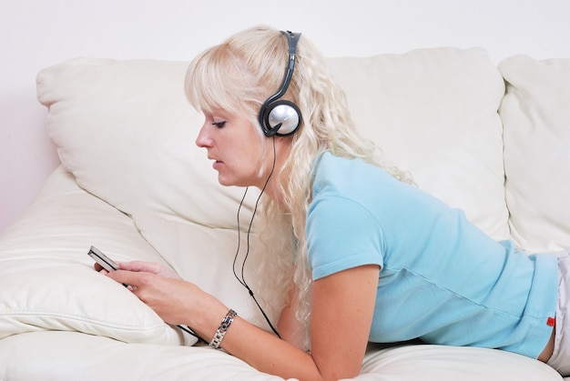 Blond kobieta słucha swojego odtwarzacza mp3
