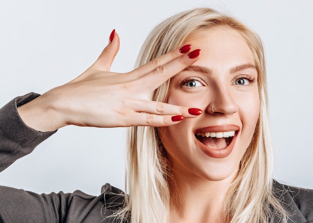 Blond kobieta szczęśliwa pokazując pokój na białym tle odizolowane