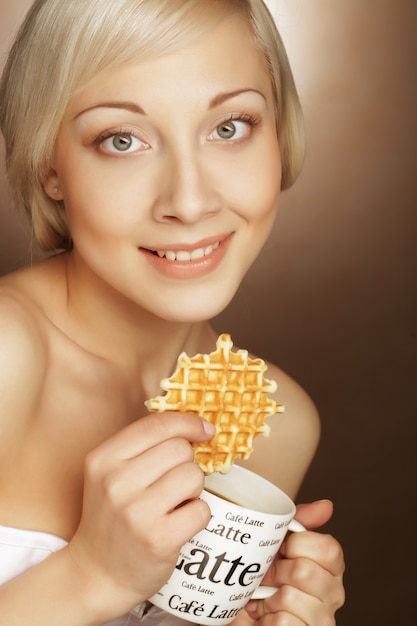 Blond kobieta z kawą i ciastkami
