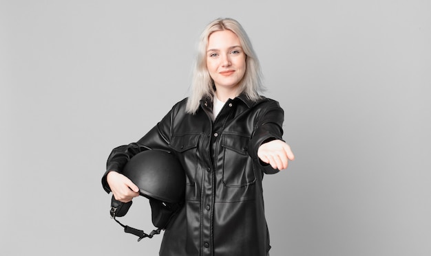 Blond ładna Kobieta Uśmiecha Się Szczęśliwie Z Przyjazną I Oferującą I Pokazującą Koncepcję. Koncepcja Motocyklisty