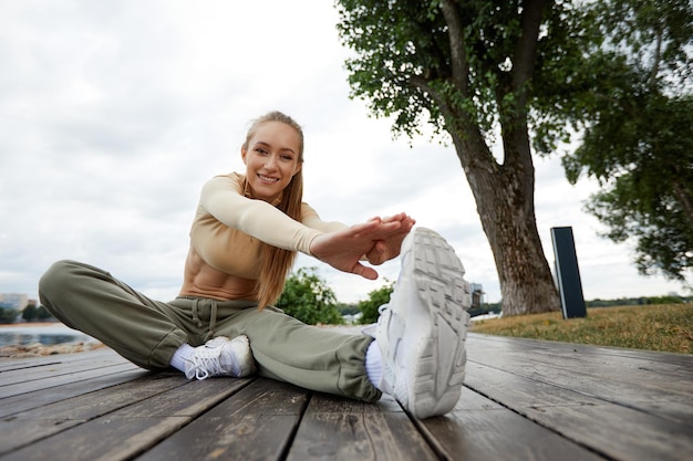 Blond młoda kobieta lekkoatletycznego robi ćwiczenia w parku w środowisku miejskim Atrakcyjna kobieta lekkoatletycznego ćwiczenia na świeżym powietrzu rano kopia przestrzeń Koncepcja fitness fitness